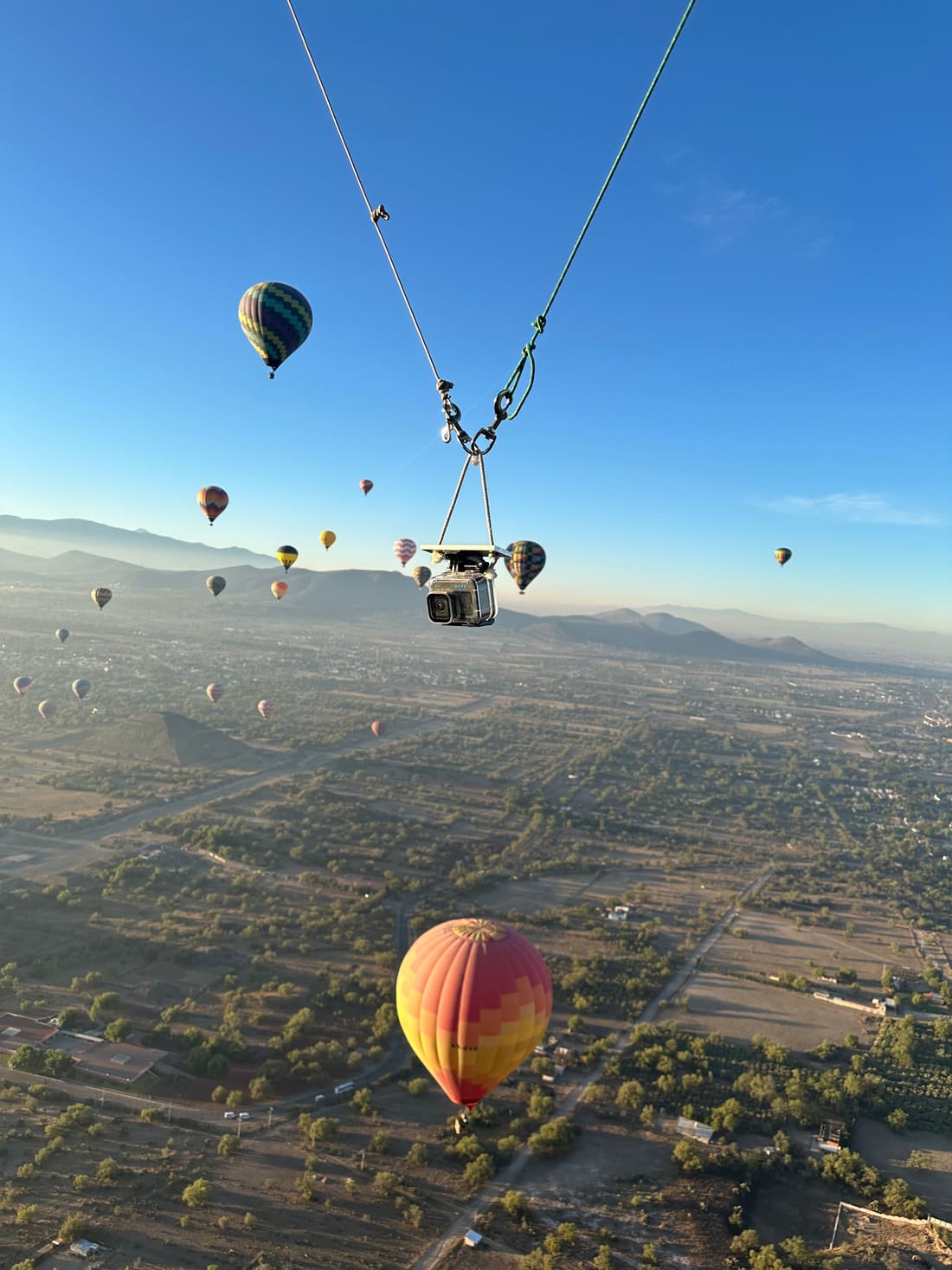 Color travel photo of hot air balloons drifting over the landscape at sunrise